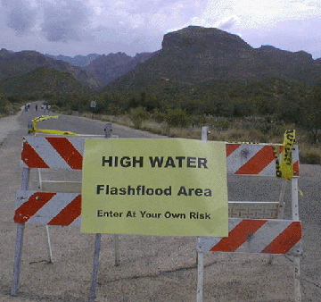 This is a photograph of a "high water, flashflood area" sign.